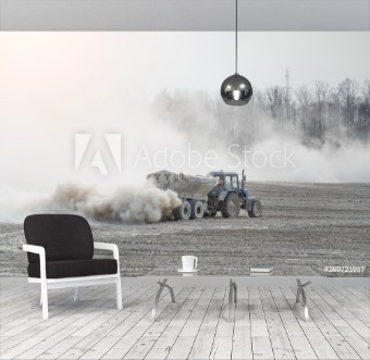 Picture of Tractor with trailer fertilizes agricultural field in spring for sowing corn